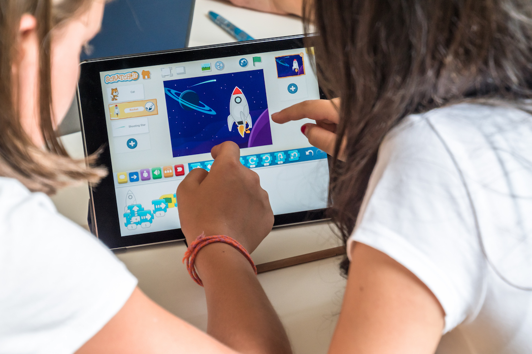 Zwei Schülerinnen entwickeln ihr Programm in ScratchJr